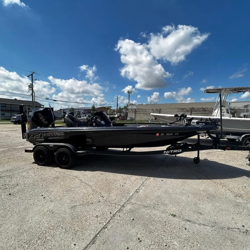 Slide: The Image of 2019 Nitro Z20 Pro bass boat on a trailer under a blue sky with clouds. - 9