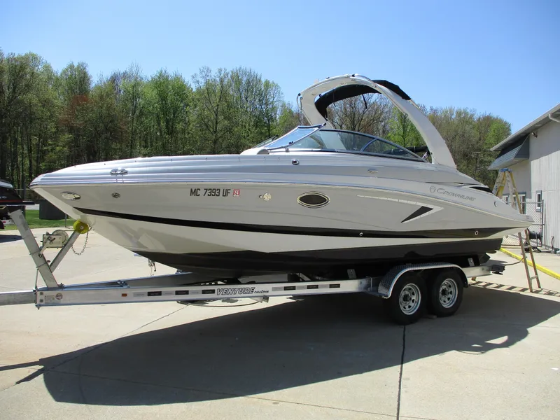 The Image of 2019 Crownline Eclipse E255 boat on a trailer in a driveway. - 1