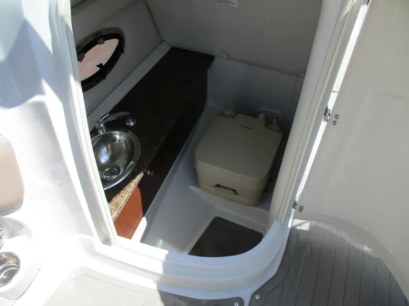 Slide: The Image of 2019 Crownline Eclipse E255 boat interior bathroom with sink and portable toilet. - 7