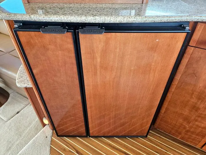 Slide: The Image of Wood-paneled refrigerator in 2007 Meridian 411 Sedan yacht interior. - 10