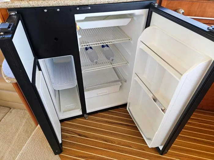 Slide: The Image of Open refrigerator in 2007 Meridian 411 Sedan yacht, showcasing interior shelves and storage. - 11