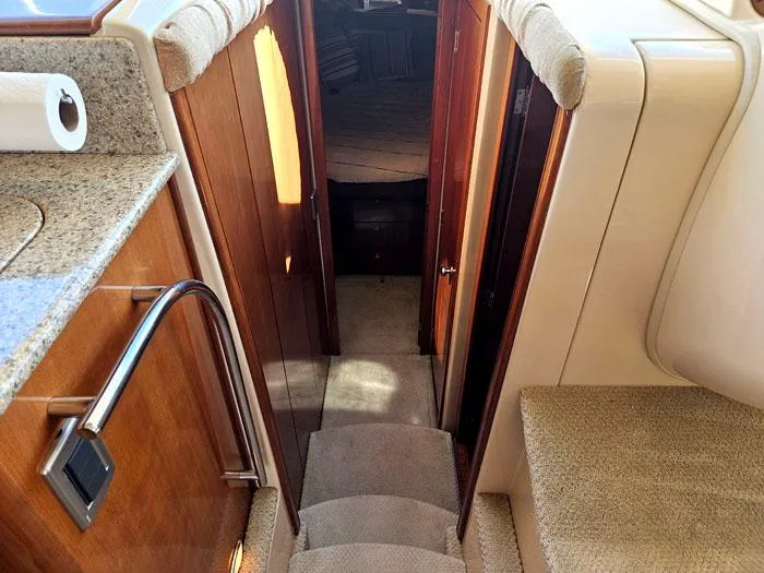 Slide: The Image of Interior of a 2007 Meridian 411 Sedan yacht, featuring a carpeted staircase and wooden cabinetry. - 13