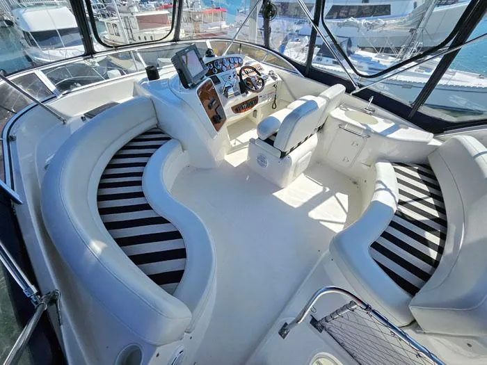 Slide: The Image of Luxurious 2007 Meridian 411 Sedan yacht interior with striped seating and modern helm. - 21
