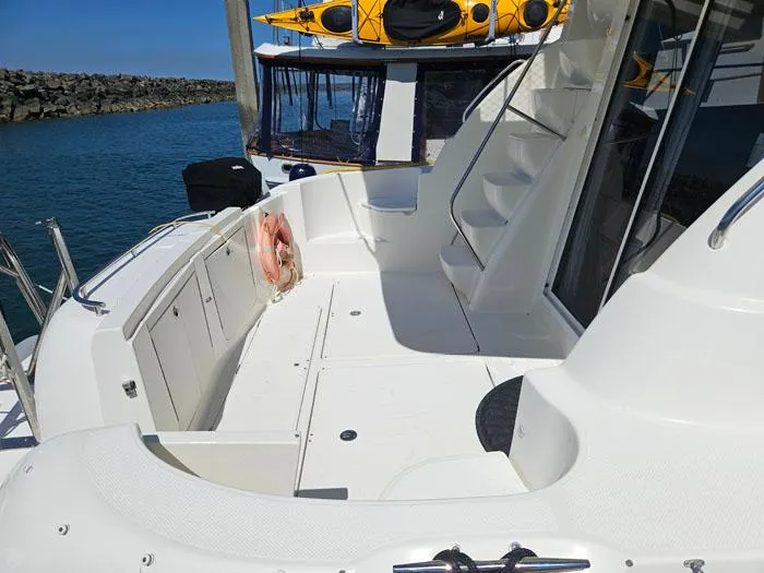 Slide: The Image of 2007 Meridian 411 Sedan yacht deck with stairs and life preserver, docked by the water. - 4