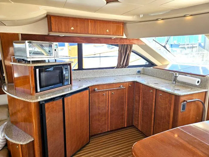 Slide: The Image of Luxurious 2007 Meridian 411 Sedan yacht kitchen with wood cabinetry and modern appliances. - 9