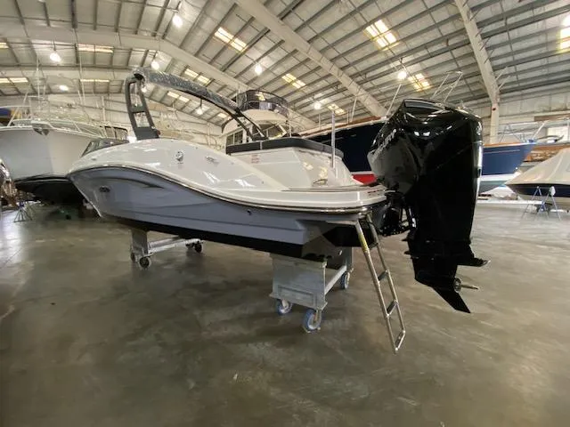 Slide: The Image of 2024 Sea Ray SPX 230 Outboard boat displayed in an indoor showroom. - 3
