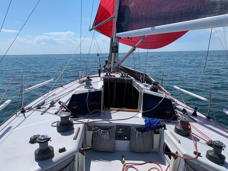 Slide: The Image of Sailing on a 1991 Tripp 36 yacht with red sails on a clear day. - 10