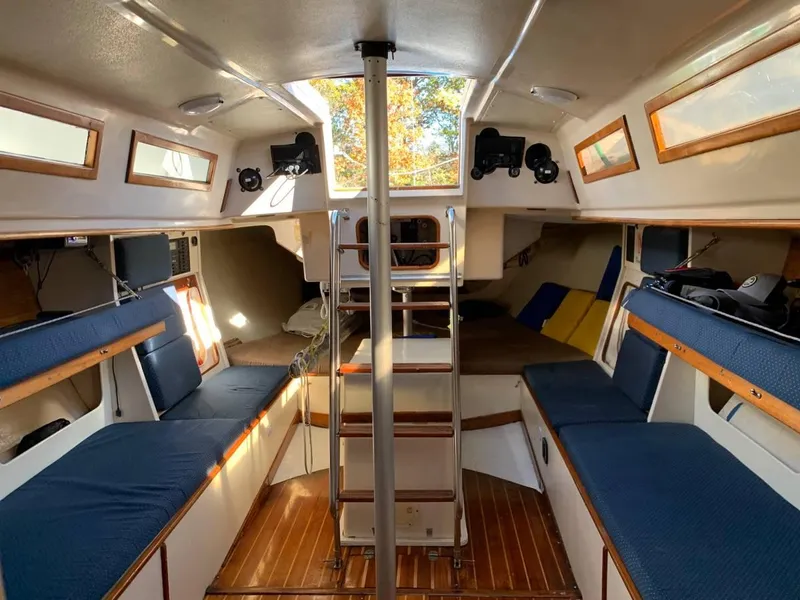 Slide: The Image of Interior of a 1991 Tripp 36 sailboat with blue seating and wooden accents. - 11