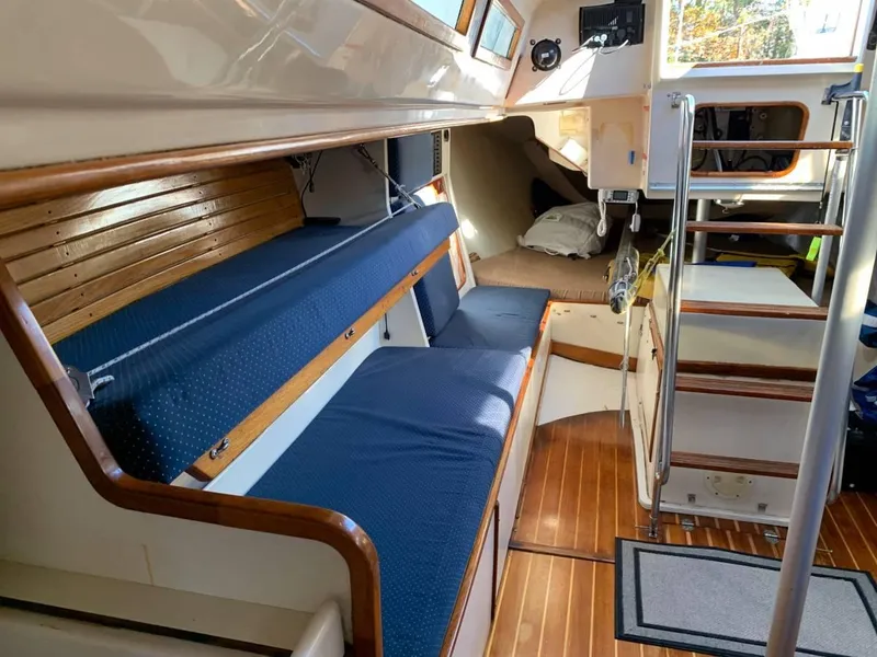 Slide: The Image of Interior of 1991 Tripp 36 sailboat with blue seating and wooden accents. - 12