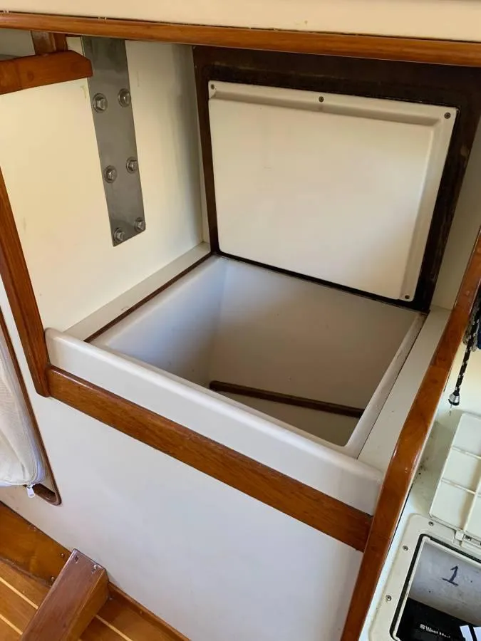 Slide: The Image of Open storage compartment on a 1991 Tripp 36 boat, featuring wooden trim. - 15