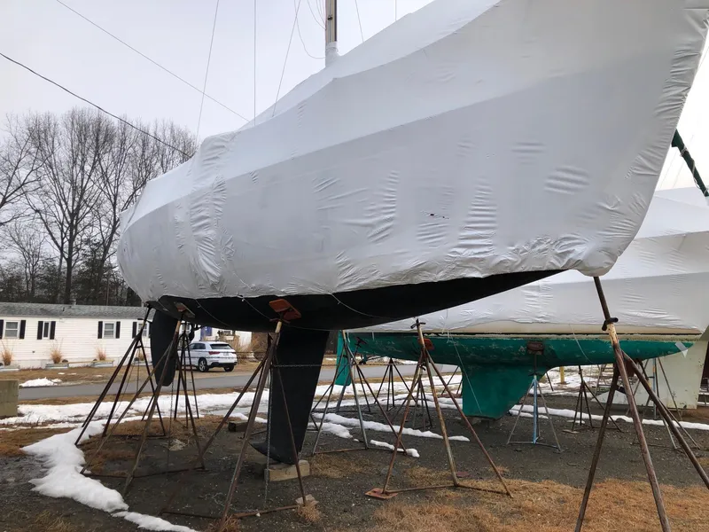 Slide: The Image of Sailboat covered in white tarp, Tripp 36 model, 1991, on stands in winter setting. - 33