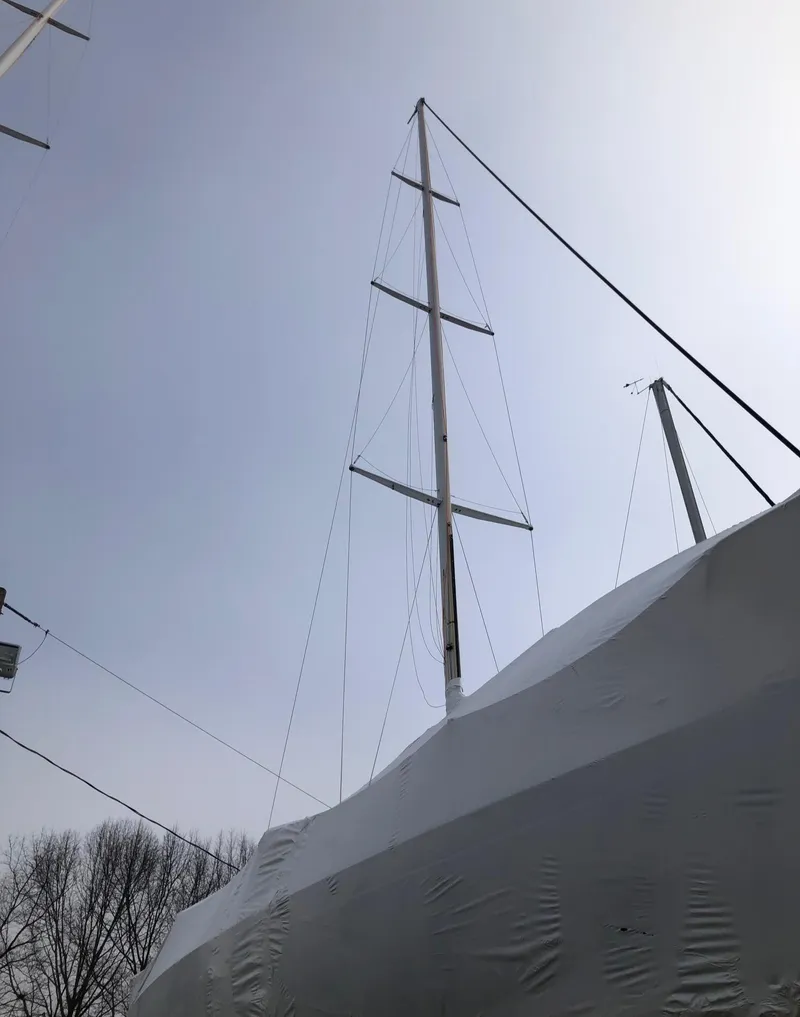 Slide: The Image of Sailboat with tall mast, covered in white tarp, Tripp 36 model, 1991. - 36