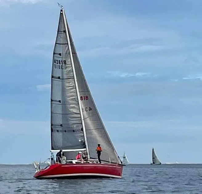 Slide: The Image of Red Tripp 36 sailboat from 1991 sailing on open water under a clear sky. - 6