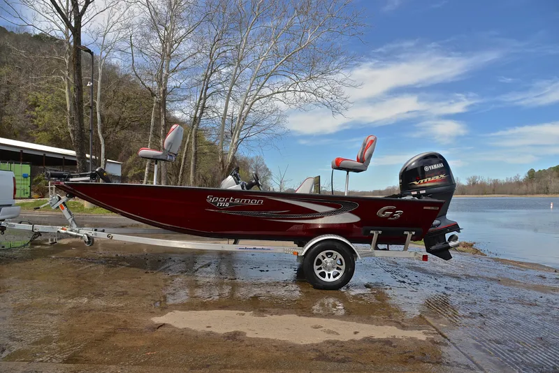 Slide: The Image of 2019 G3 Sportsman 1710 fishing boat on trailer by a lake. - 11