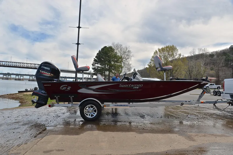Slide: The Image of 2019 G3 Sportsman 1710 fishing boat on trailer by a lake. - 15
