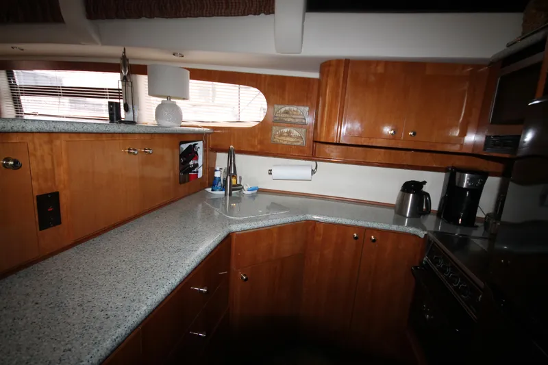 Slide: The Image of 2001 Carver 466 Motor Yacht kitchen with wooden cabinets and granite countertops. - 15