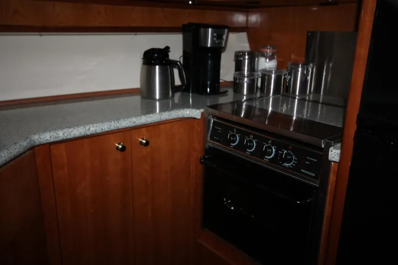 Slide: The Image of 2001 Carver 466 Motor Yacht kitchen with stove, coffee maker, and storage cabinets. - 16