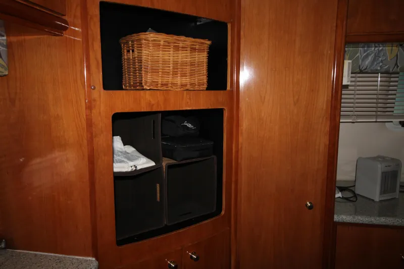 Slide: The Image of Interior storage space on a 2001 Carver 466 Motor Yacht with wooden cabinets. - 34