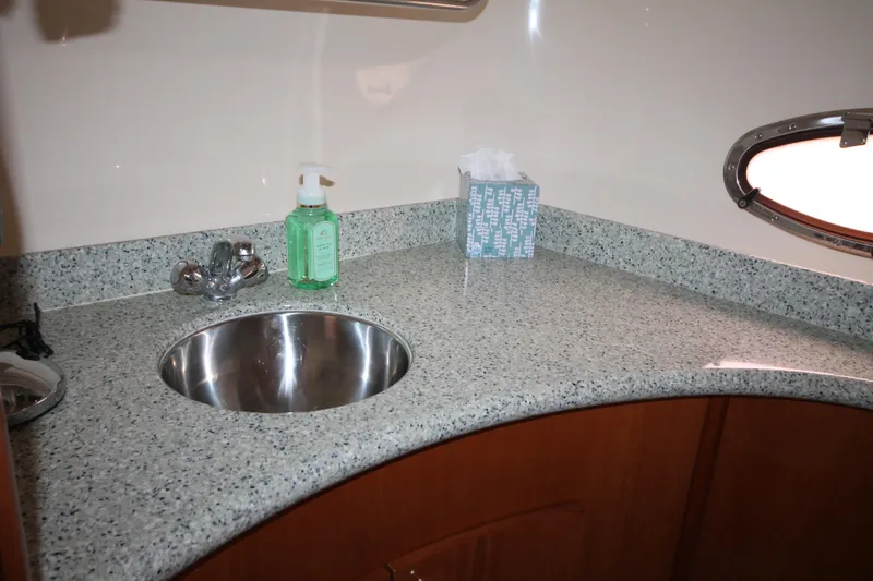 Slide: The Image of 2001 Carver 466 Motor Yacht bathroom sink with granite countertop and porthole window. - 37