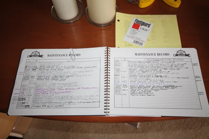 Slide: The Image of Maintenance record book for 2001 Carver 466 Motor Yacht on a wooden table. - 41