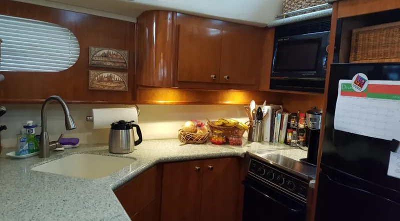 Slide: The Image of 2001 Carver 466 Motor Yacht kitchen with modern appliances and wooden cabinetry. - 5