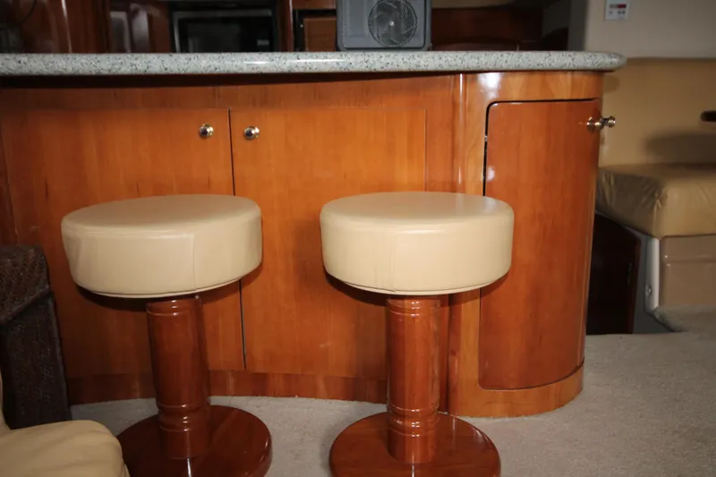 Slide: The Image of Interior of 2001 Carver 466 Motor Yacht with bar stools and wooden cabinetry. - 7