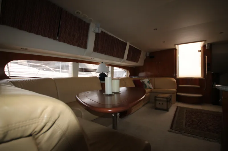 Slide: The Image of Interior of 2001 Carver 466 Motor Yacht with beige leather seating and wooden table. - 9