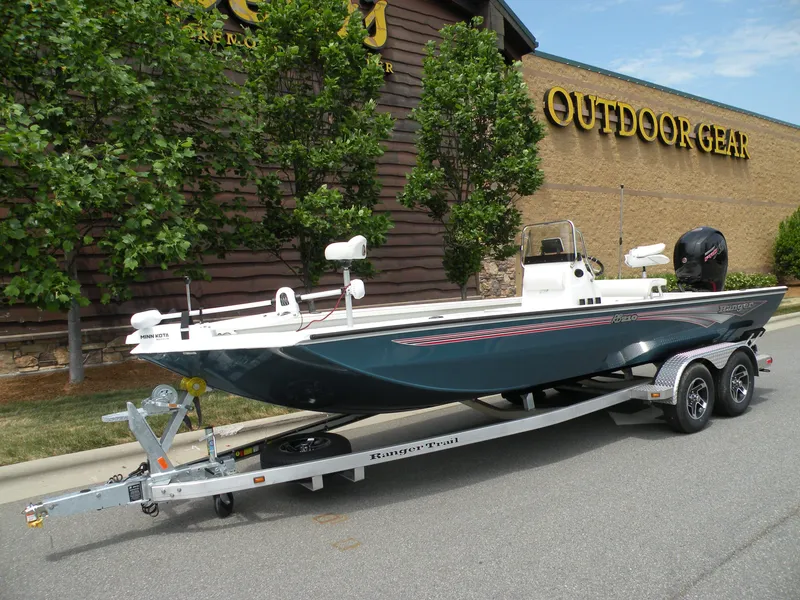 Slide: The Image of 2024 Ranger RB210 boat on trailer outside outdoor gear store. - 1