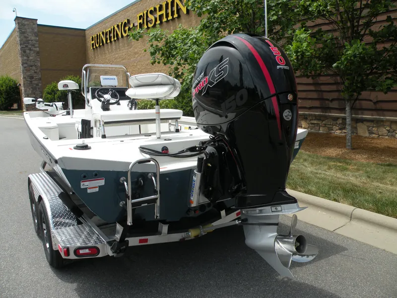 Slide: The Image of 2024 Ranger RB210 boat with outboard motor in parking lot near Hunting-Fishing store. - 3