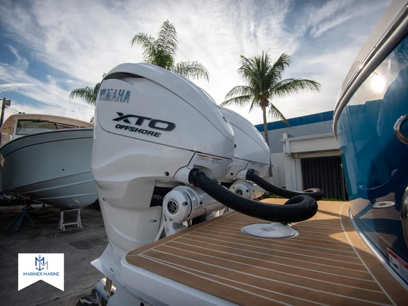 Slide: The Image of 2024 Regulator 31 boat with Yamaha XTO Offshore engines, docked near palm trees. - 10