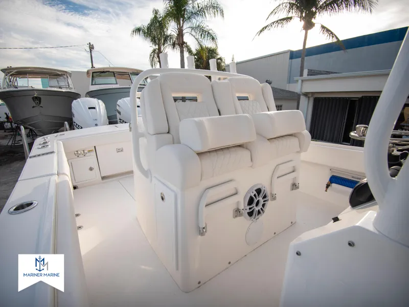 Slide: The Image of 2024 Regulator 31 boat interior with white seating and palm trees in the background. - 31