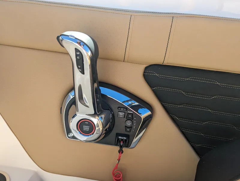 Slide: The Image of 2024 Sea Ray SPX 230 boat throttle control on tan and black interior. - 13