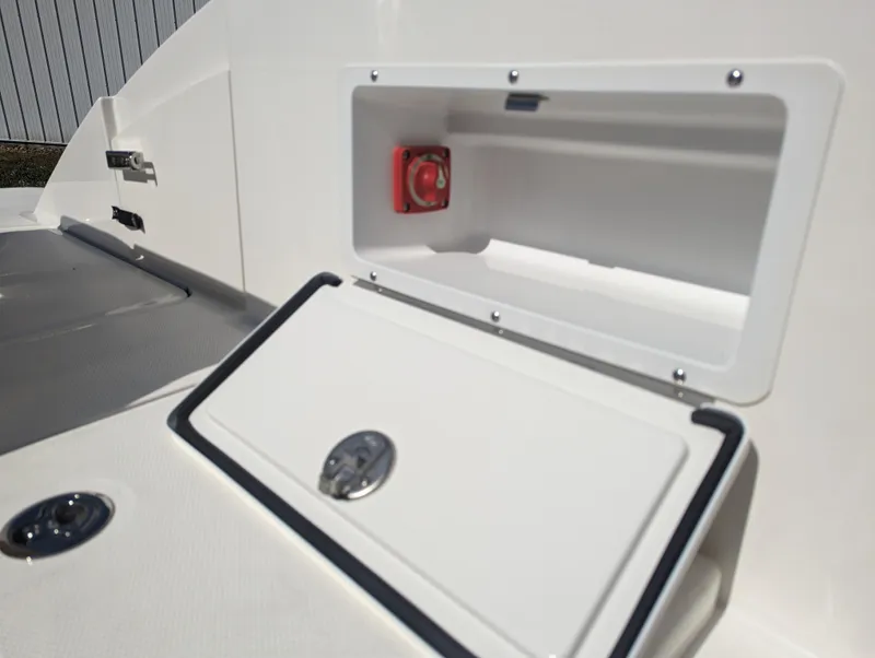Slide: The Image of 2024 Sea Ray SPX 230 boat storage compartment and control switch. - 25