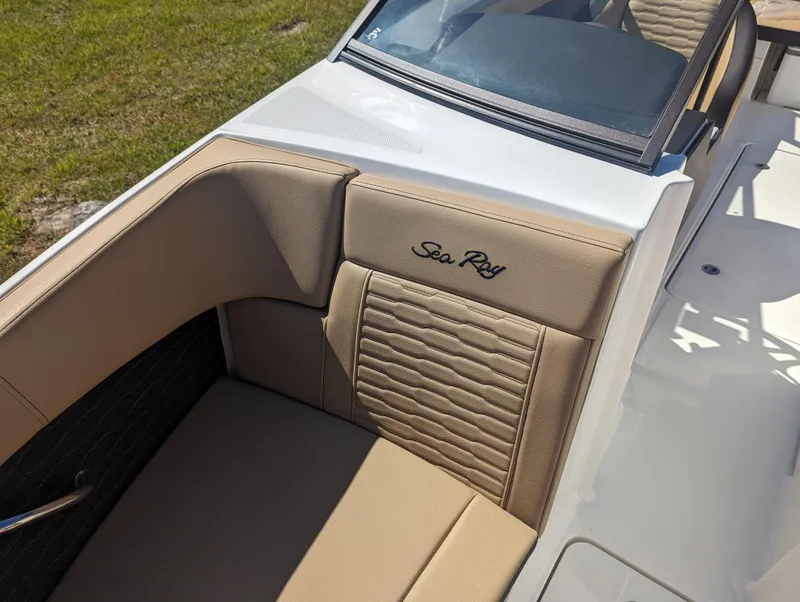 Slide: The Image of 2024 Sea Ray SPX 230 boat interior with tan upholstery and embroidered logo. - 9