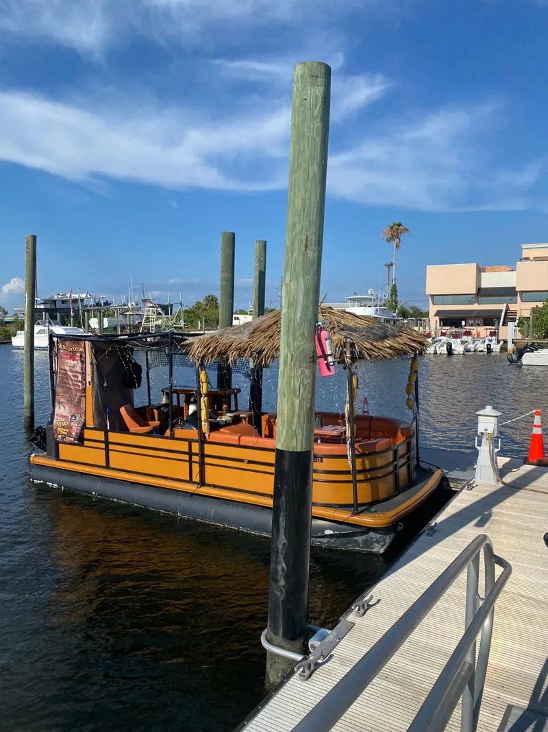 Slide: The Image of Custom Tiki Bahama Mama 1.0 boat docked at marina, 2024 model. - 4