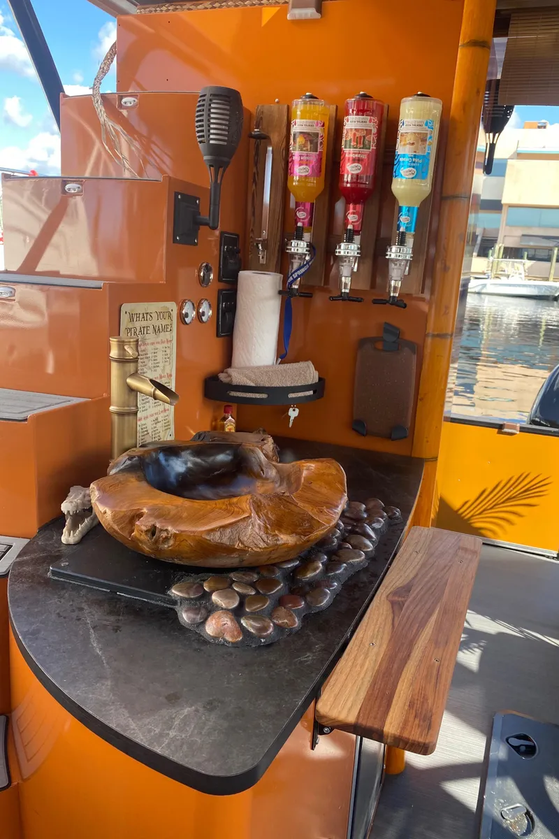 Slide: The Image of Custom Tiki Bahama Mama 2.0 2024 outdoor bar with drink dispensers and rustic decor. - 8