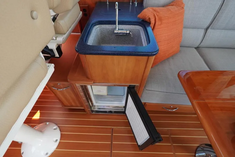 Slide: The Image of 2012 Sabre 48 Salon Express interior with sink, mini-fridge, and seating area. - 12