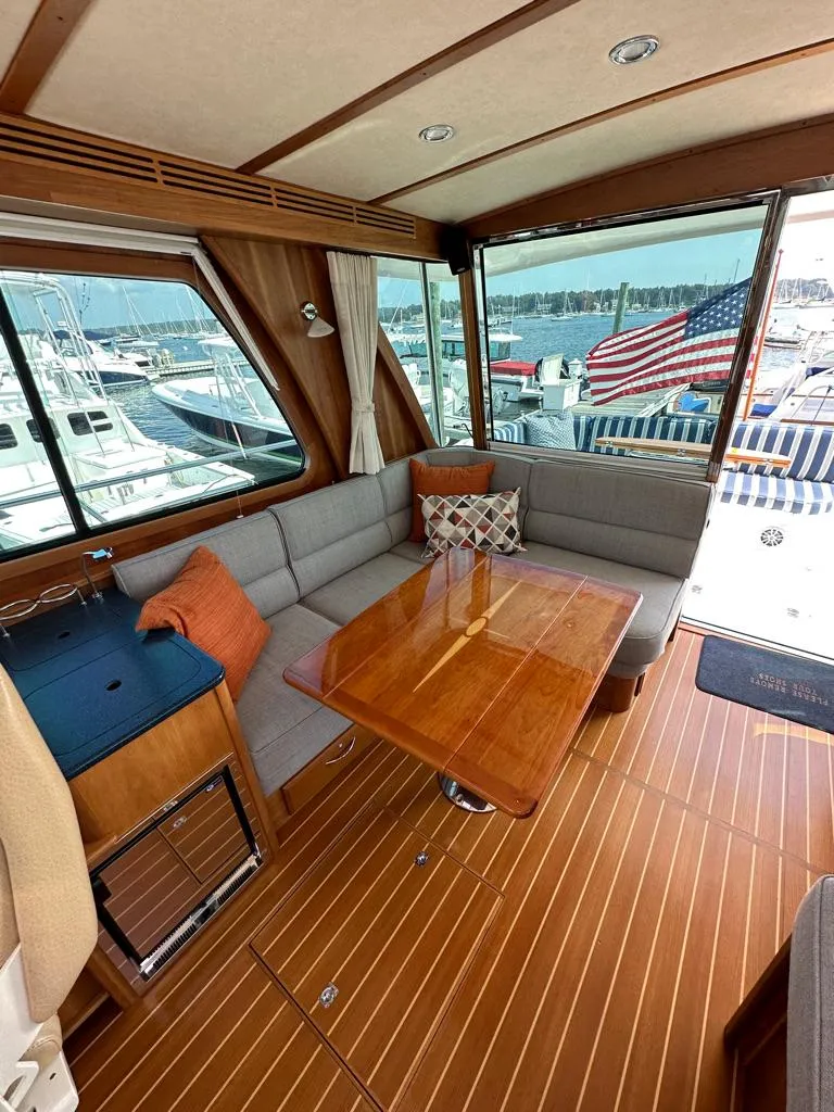 Slide: The Image of Interior of 2012 Sabre 48 Salon Express yacht with wooden table and cushioned seating. - 13