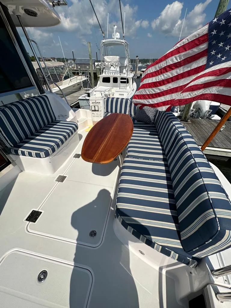 Slide: The Image of 2012 Sabre 48 Salon Express yacht with striped seating and American flag. - 6