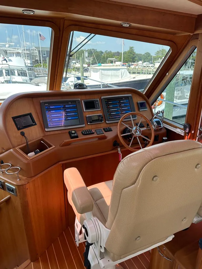 Slide: The Image of Helm station of a 2012 Sabre 48 Salon Express yacht with navigation screens and captain's chair. - 8