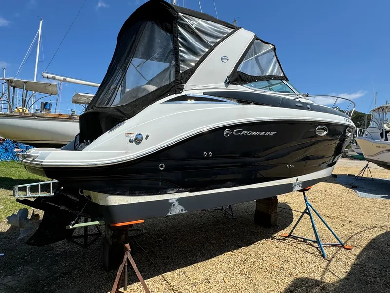 Slide: The Image of 2020 Crownline 264CR boat on stands, black and white exterior, outdoor setting. - 12