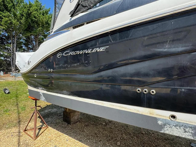 Slide: The Image of 2020 Crownline 264CR boat on stand, side view, outdoors. - 13