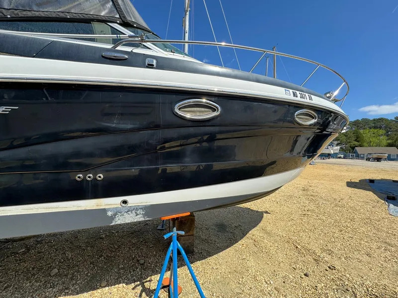 Slide: The Image of 2020 Crownline 264CR boat on dry dock, blue hull, sunny day. - 15