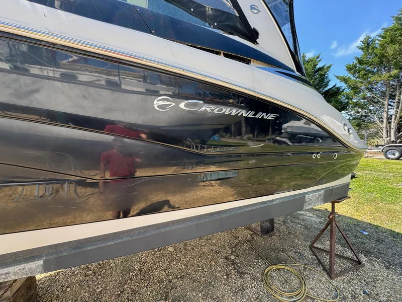 Slide: The Image of 2020 Crownline 264CR boat on a stand, side view, outdoors. - 19
