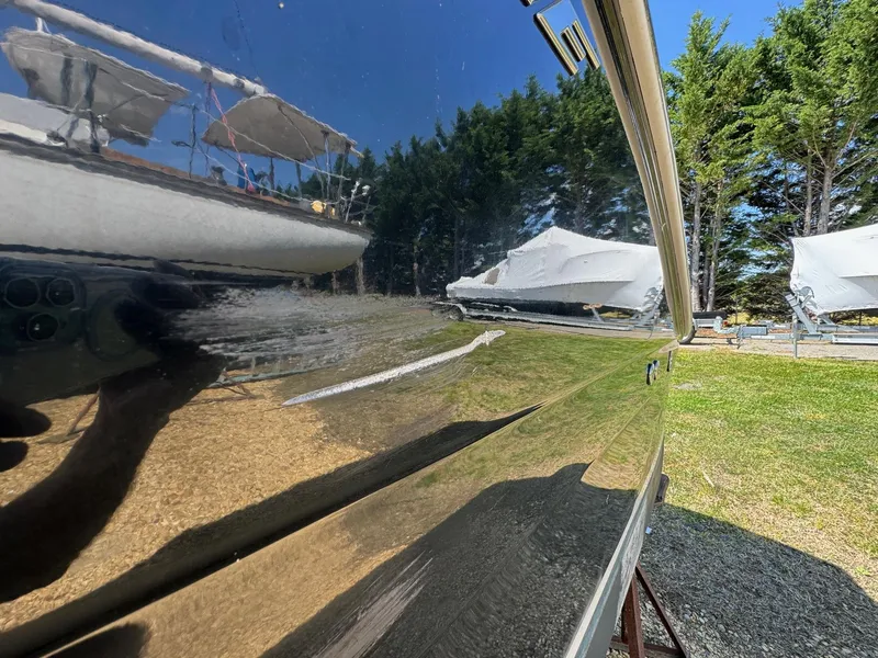 Slide: The Image of 2020 Crownline 264CR boat reflecting trees and other boats in a sunny outdoor setting. - 20
