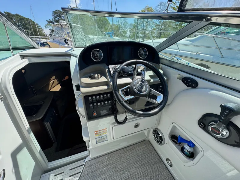 Slide: The Image of 2020 Crownline 264CR boat cockpit with steering wheel and control panel. - 31