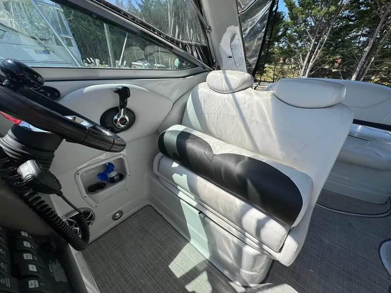 Slide: The Image of 2020 Crownline 264CR boat interior with steering wheel and white seating. - 34