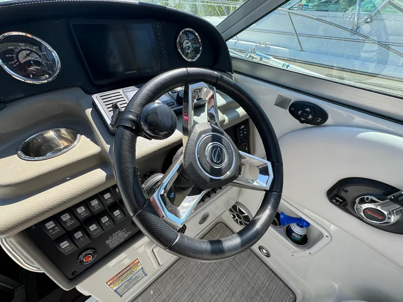 Slide: The Image of 2020 Crownline 264CR boat dashboard with steering wheel and controls. - 42