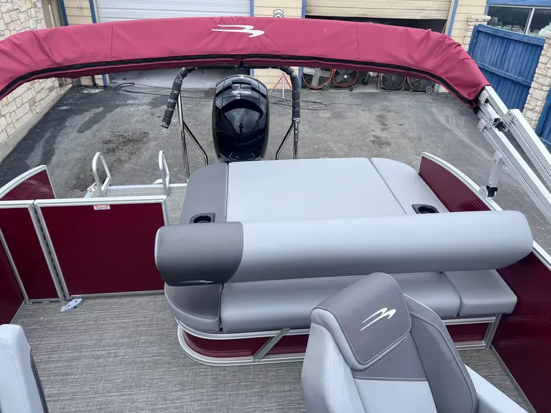 Slide: The Image of 2024 Bennington 22SV pontoon boat with maroon canopy and gray seating. - 10