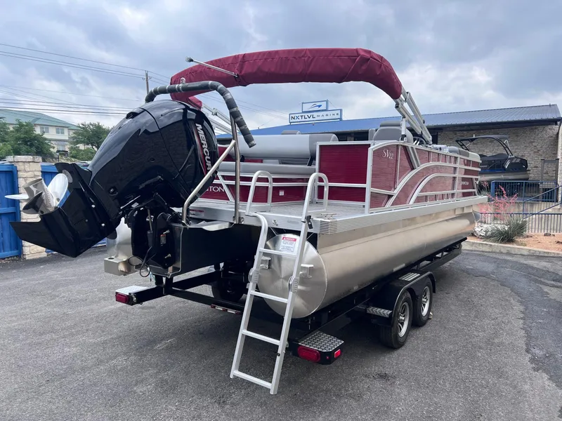 Slide: The Image of 2024 Bennington 22SV pontoon boat with Mercury engine on trailer, parked outdoors. - 4